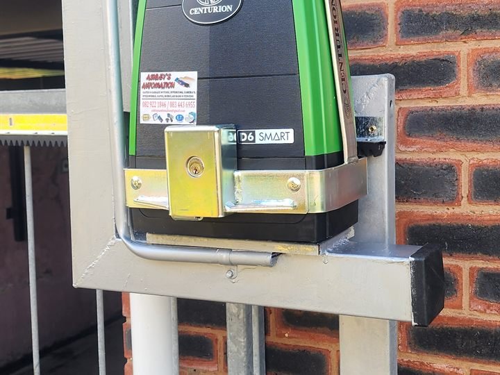 Gate motor mounted in a steel anti-theft bracket on a brick pillar